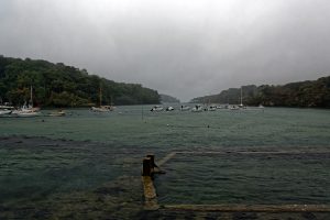 Japanische Touristen passieren im Regen das Château de Belon