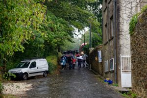 Japanische Touristen passieren im Regen das Château de Belon