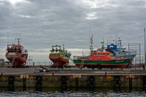Im Hafen von Le Guilvinec auf dem Pier auf dem Gelände der Reparaturwerft aufgebockte Fischtrawler