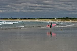 Surferin auf dem Weg ins Wasser hat sich vermutlich eine Muschel in den Fuß getreten