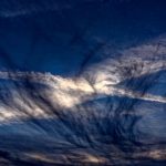 Wind verwischt Schleierwolken und Kondensstreifen der Passagierjets zu einem Gemälde