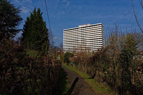 Das Hochhaus des Bonn-Centers von den Schrebergärten jenseits der Bahnlinie aus gesehen. Es steckt in den Vorbereitungen für die Sprengung